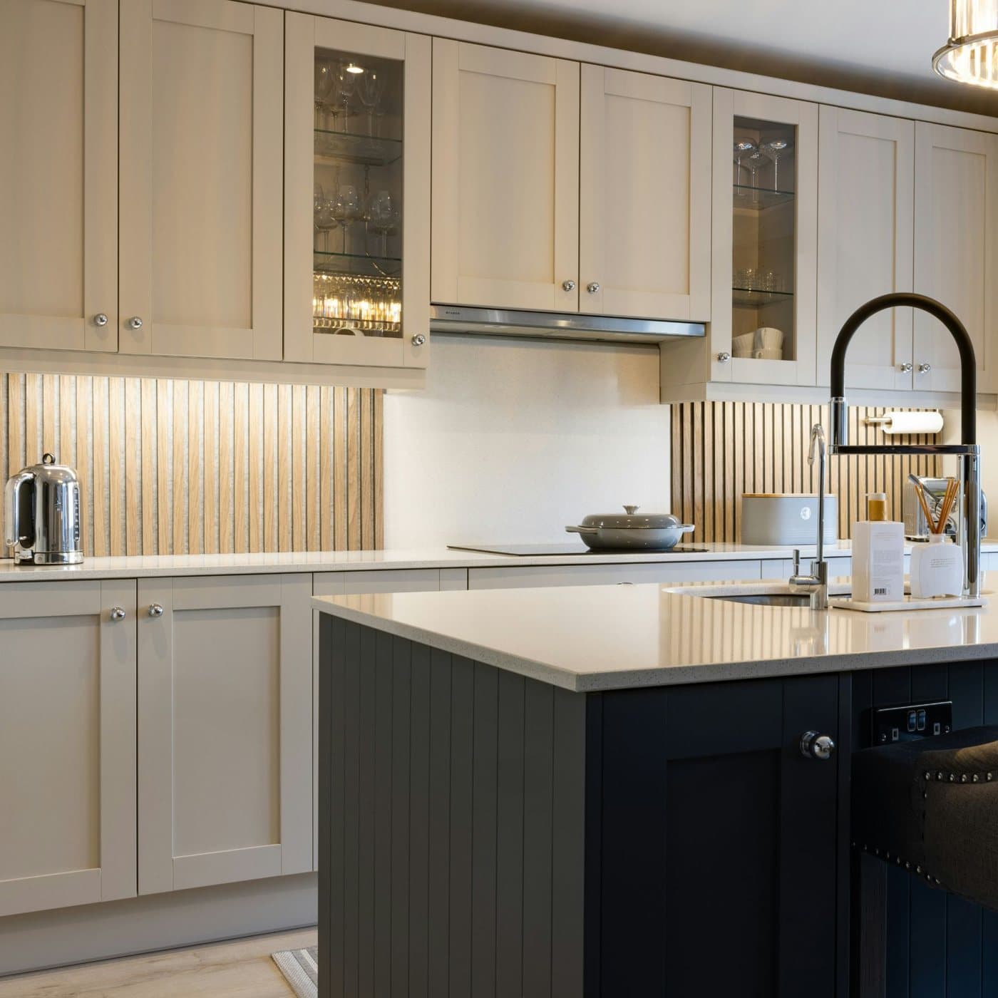 Cocina con gabinetes claros, muebles aéreos e isla